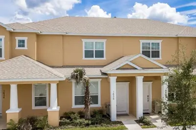 a house with a palm tree in front of it at Charming Cozy Haven in Orlando
