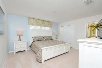 a white bedroom with a bed and a window at Spacious Cozy Comfort in Every Corner in Kissimmee