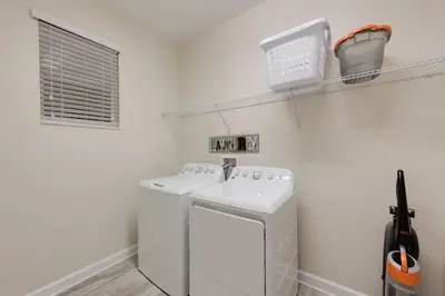 a white laundry room with a washer and dryer at Chic Luxury Haven - Unforgettable Retreat in Kissimmee