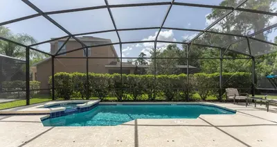 a swimming pool with a glass enclosure around it at Enjoy the Large Pool - 6BR BL220 in Kissimmee