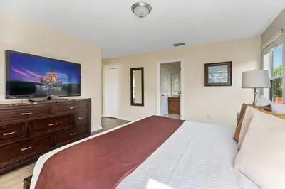a bedroom with a bed and a flat screen tv at Enjoy the Large Pool - 6BR BL220 in Kissimmee
