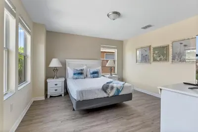 a bedroom with a bed and two tables and two lamps at Enjoy the Large Pool - 6BR BL220 in Kissimmee