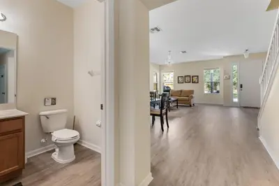 a bathroom with a toilet and a dining room at Enjoy the Large Pool - 6BR BL220 in Kissimmee