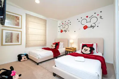 two beds in a bedroom with hello kitty stickers on the wall at Spectacular House with 3BR - Private Pool, BBQ - Minutes from Disney! in Kissimmee