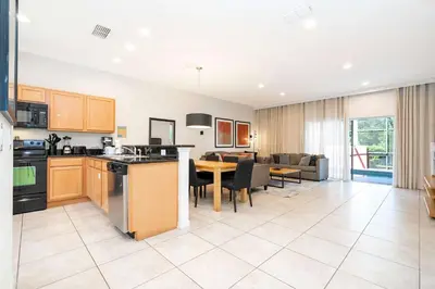 a kitchen and living room with a table and a dining room at Spectacular House with 3BR - Private Pool, BBQ - Minutes from Disney! in Kissimmee