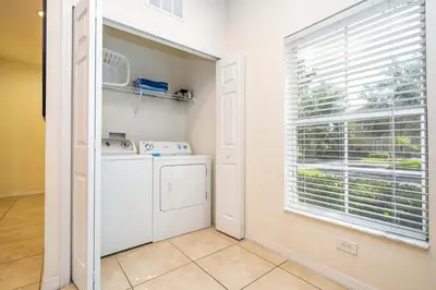 a laundry room with a washing machine and a window at Spectacular House with 3BR - Private Pool, BBQ - Minutes from Disney! in Kissimmee