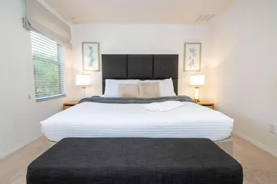 a bedroom with a large white bed with two lamps at Spectacular House with 3BR - Private Pool, BBQ - Minutes from Disney! in Kissimmee
