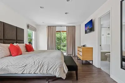a bedroom with a large bed and a bathroom at 4 BR Hot Tub Cozy Decor @ Regal Oaks RO2761N in Kissimmee