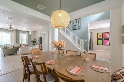 a dining room and living room with a table and chairs at 8575 - 7th Heaven Villa in Kissimmee
