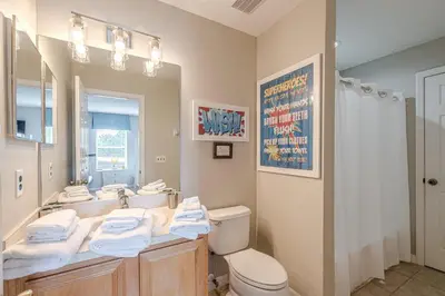 a bathroom with a sink and a toilet and a mirror at 8575 - 7th Heaven Villa in Kissimmee