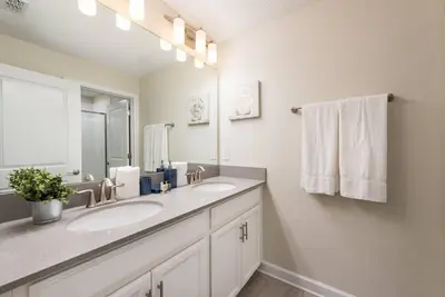 a bathroom with two sinks and a large mirror at Themed 4BR Home-Mickey & Star Wars Pool Spacious in Kissimmee