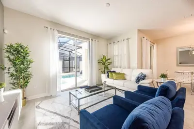 a living room with a blue couch and a table at Themed 4BR Home-Mickey & Star Wars Pool Spacious in Kissimmee