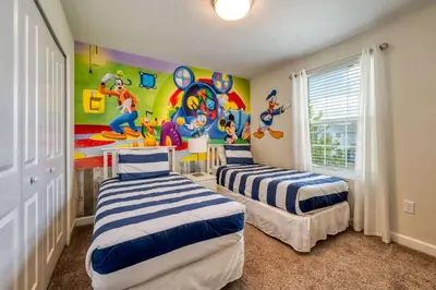 two beds in a room with a mural on the wall at Stunning Home Private Pool Great Location in Kissimmee