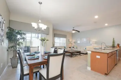 a dining room and living room with a table and chairs at Charming 4 BDR townhome at Storey Lake Resort in Kissimmee