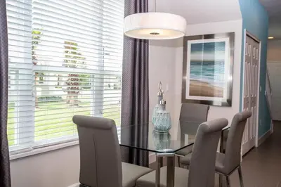 a dining room with a glass table and chairs at Serene Villa with Private Pool in Orlando
