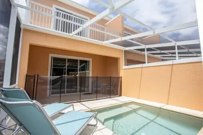 a balcony with a swimming pool and chairs and a building at Serene Villa with Private Pool in Orlando