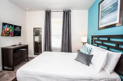 a bedroom with a large white bed and blue walls at Serene Villa with Private Pool in Orlando