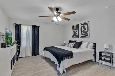 a white bedroom with a bed and a ceiling fan at Modern Lake Front Casita near Winter Park! in Orlando