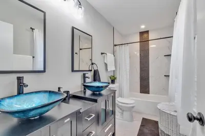 a bathroom with two blue sinks and a toilet at Modern Lake Front Casita near Winter Park! in Orlando