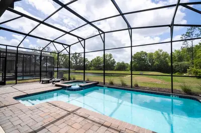 a swimming pool in a glass house with a view at Modern Marvel-Spacious, Themed, Fun-Filled in Kissimmee