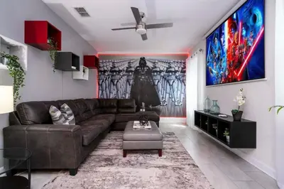 a living room with a brown couch and a painting at Modern Marvel-Spacious, Themed, Fun-Filled in Kissimmee