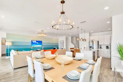 a dining room and living room with a table and chairs at Upstay Lakeside 10 Bedroom Home with Pool Private Cinema & Game Room in Kissimmee