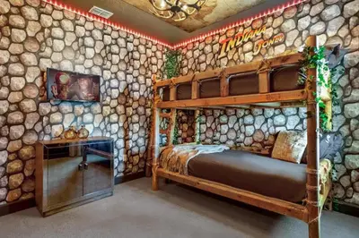 a bedroom with a wooden bunk bed and a wall of logs at Upstay Lakeside 10 Bedroom Home with Pool Private Cinema & Game Room in Kissimmee