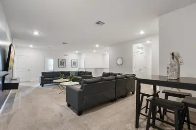 a living room with two couches and a table at Spacious Family Reunion 15BR Home Pool Spa Game Rm in Kissimmee
