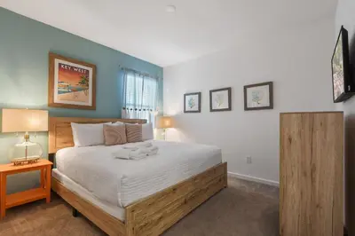a bedroom with a large bed with a wooden frame at Spacious Family Reunion 15BR Home Pool Spa Game Rm in Kissimmee