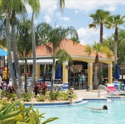 a pool at a resort with people in the water at Roomy House Near Disney with Resort Pool and Patio BBQ in Kissimmee