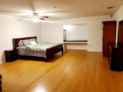 a bedroom with a bed and a wooden floor at The Farm House in Sanford