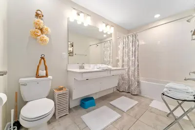 a bathroom with a toilet and a sink and a tub at Storey Lake: Apartment with lake view in Kissimmee