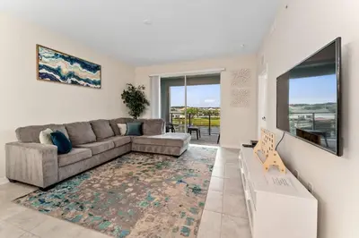 a living room with a couch and a large window at Storey Lake: Apartment with lake view in Kissimmee