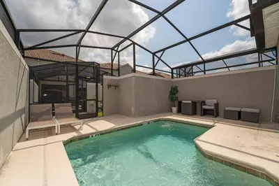 an indoor swimming pool with a glass roof at Townhome with pool at Storey Lake in Kissimmee