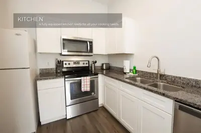 a kitchen with white cabinets and stainless steel appliances at Stunning 3BD Condo 14 Mins to Disney World , Gated in Kissimmee