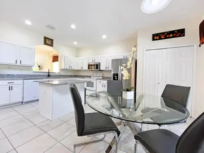 a kitchen with a glass table and black chairs at Golden Beach Villa home in Kissimmee