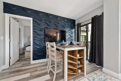 a dining room with a table and a blue wall at Apartment with Volcano Bay view in Orlando