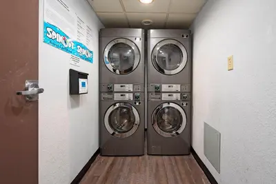 two washing machines in a laundry room with a hallway at Apartment with Volcano Bay view in Orlando