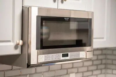 a microwave oven in a kitchen with white cabinets at Apartment with Volcano Bay view in Orlando