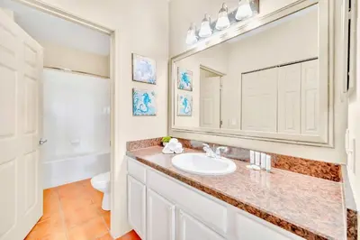 a bathroom with a sink and a mirror at Modern 2BR Condo - Pool - Near Disney in Orlando