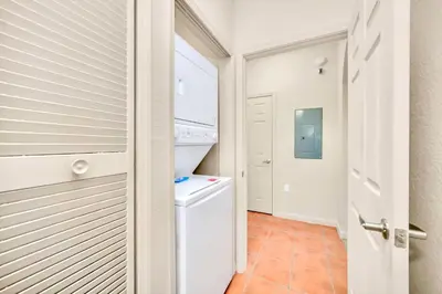 a small laundry room with a washer and dryer at Modern 2BR Condo - Pool - Near Disney in Orlando