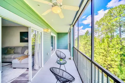 a porch with a couch and chairs on a balcony at Modern 2BR Condo - Pool - Near Disney in Orlando