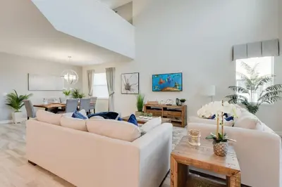 a living room with white couches and a table at Luxury 5BR Home, Private Pool, Prime Location in Kissimmee