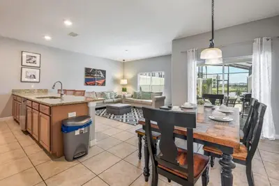 an open kitchen and living room with a table and chairs at Cozy Home Near Disney Parks - Prime Location in Kissimmee