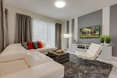 a white living room with a white couch and chairs at Cozy Home Prime Disney Parks Location in Kissimmee
