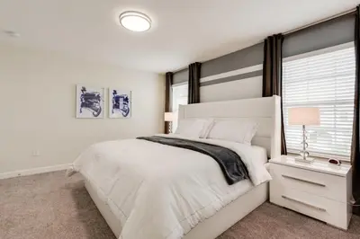 a white bedroom with a large bed and a window at Cozy Home Prime Disney Parks Location in Kissimmee