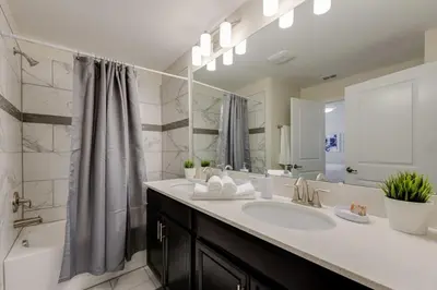 a bathroom with a sink and a tub and a shower at Cozy Home Prime Disney Parks Location in Kissimmee