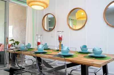 a dining room with a table with chairs and mirrors at Vibrant Themed Home Prime Location in Kissimmee