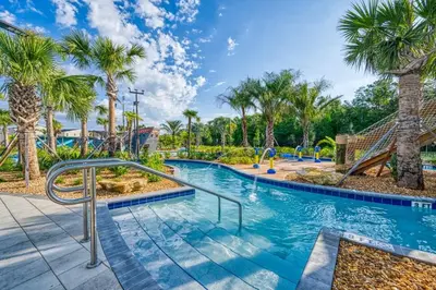 a pool with palm trees and a slide at Modern Chic-Spacious, Private Pool, Prime Location in Kissimmee