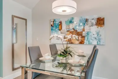 a dining room with a glass table and chairs at Cozy Villa Private Pool Prime Spot in Orlando